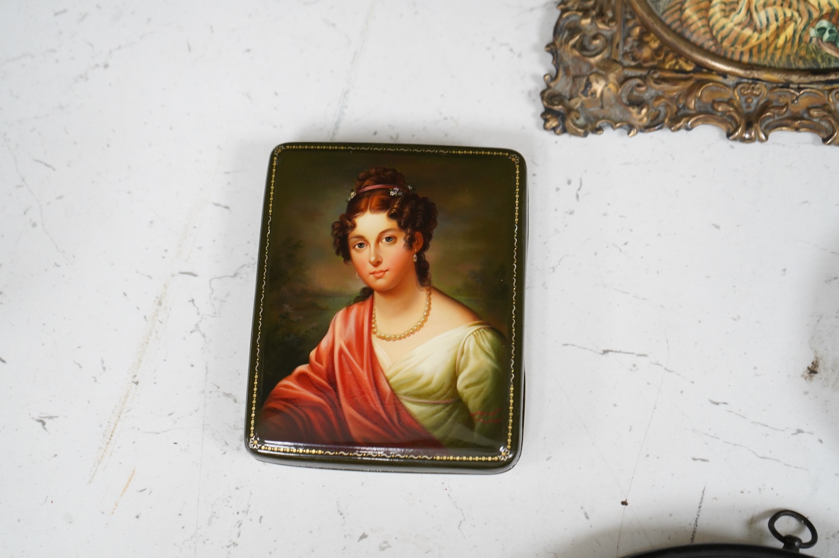 A collection of 19th century porcelain panels, pot lids and plaques to include a pair of hand painted floral lids, Russian lacquered box depicting a lady and a late 19th century Continental brass framed convex oval ename